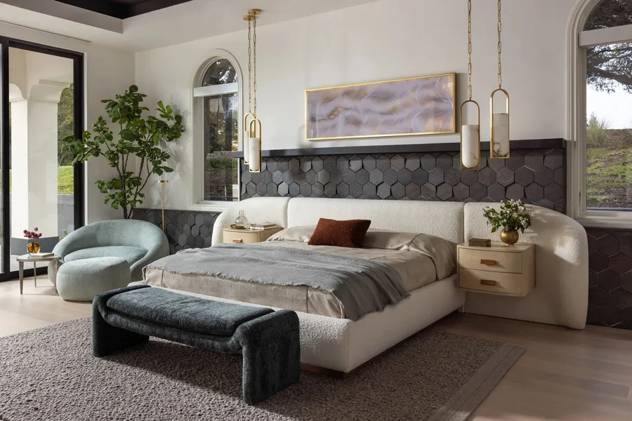 A bedroom with a curved headboard and a dark wood feature wall.